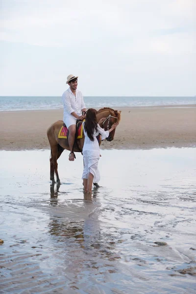 Romantic Couple With horse riding At the beach in the afternoon On a sweet holiday