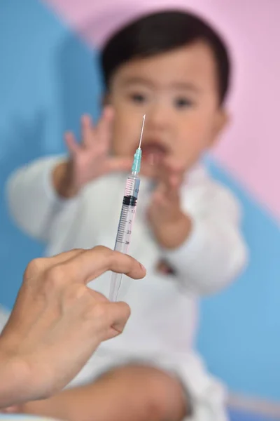 Young Man Syringe Hand Baby Background — Stock Photo, Image