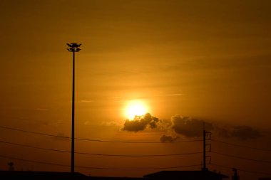 Güç iletim sistemiyle gökyüzü ve parlak gün güzel bulutlarda. Polonyalılar ve güç hatları ile altın günbatımı.