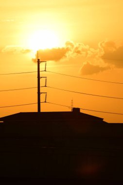 Güç iletim sistemiyle gökyüzü ve parlak gün güzel bulutlarda. Polonyalılar ve güç hatları ile altın günbatımı.