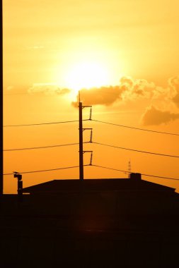 Güç iletim sistemiyle gökyüzü ve parlak gün güzel bulutlarda. Polonyalılar ve güç hatları ile altın günbatımı.