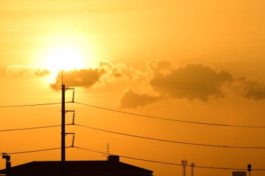 Güç iletim sistemiyle gökyüzü ve parlak gün güzel bulutlarda. Polonyalılar ve güç hatları ile altın günbatımı.