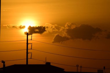 Güç iletim sistemiyle gökyüzü ve parlak gün güzel bulutlarda. Polonyalılar ve güç hatları ile altın günbatımı.