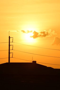Güç iletim sistemiyle gökyüzü ve parlak gün güzel bulutlarda. Polonyalılar ve güç hatları ile altın günbatımı.