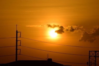 Güç iletim sistemiyle gökyüzü ve parlak gün güzel bulutlarda. Polonyalılar ve güç hatları ile altın günbatımı.