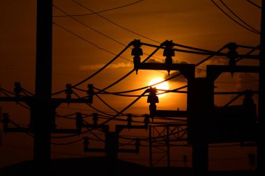 Güç iletim sistemiyle gökyüzü ve parlak gün güzel bulutlarda. Polonyalılar ve güç hatları ile altın günbatımı.