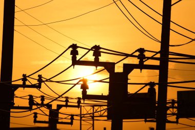 Güç iletim sistemiyle gökyüzü ve parlak gün güzel bulutlarda. Polonyalılar ve güç hatları ile altın günbatımı.