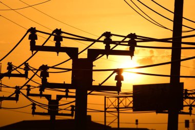 Güç iletim sistemiyle gökyüzü ve parlak gün güzel bulutlarda. Polonyalılar ve güç hatları ile altın günbatımı.