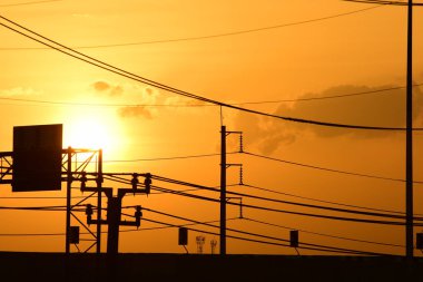 Güç iletim sistemiyle gökyüzü ve parlak gün güzel bulutlarda. Polonyalılar ve güç hatları ile altın günbatımı.