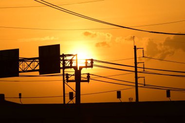 Güç iletim sistemiyle gökyüzü ve parlak gün güzel bulutlarda. Polonyalılar ve güç hatları ile altın günbatımı.