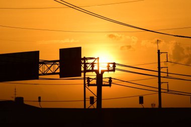 Güç iletim sistemiyle gökyüzü ve parlak gün güzel bulutlarda. Polonyalılar ve güç hatları ile altın günbatımı.