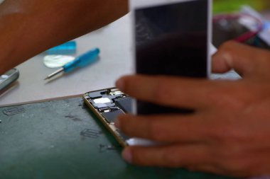 Cep telefonları ve tablet yetenekli teknisyenler tarafından onarılıyor. Deneyimli test ve onay cep telefonları. Önce ve sonra Repairtools ve onarım ve cep telefonu açmak için donatım.