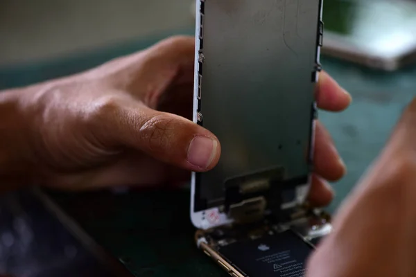 smartphone, Repairing mobile phones and tablets by skilled technicians.Experienced testers and check mobile phones. Before and After Repair Tools and equipment for repairing and unpacking mobile phones.technician repairing broken mobile.
