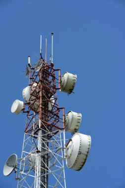 Kablosuz iletişim anteni ile parlak gökyüzü. Telekomünikasyon kule mavi gökyüzü ile antenler ile.