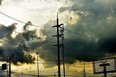 Bulutlu gökyüzü arka plan üzerinde elektrikli direkleri