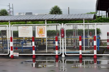 Endüstriyel istasyon, çitlerin arkasında borular var.