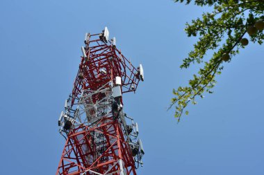 Wireless Communication Antenna With bright sky.Telecommunication tower with antennas with blue sky. clipart
