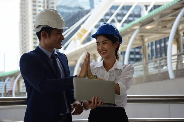 Two architects is using laptop on construction site