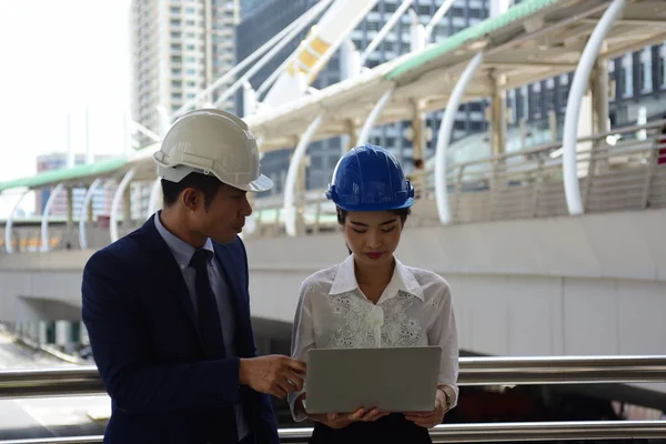 Two architects is using laptop on construction site