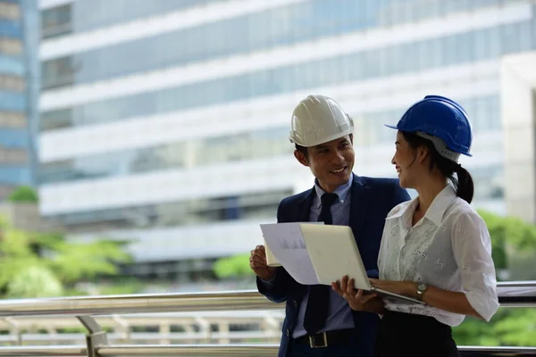 Two architects is using laptop on construction site