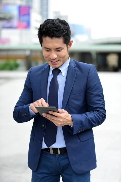 Young businessmen holding money to prepare.Image of happy young businessman standing over gray wall holding money.Businessman holding money with smiling. Business man with business success concept.