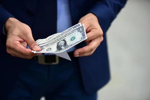 Young businessmen holding money to prepare.Image of happy young businessman standing over gray wall holding money.Businessman holding money with smiling. Business man with business success concept.