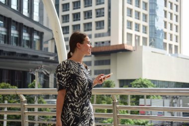 Bavullu ve cep telefonlu bir kadın.