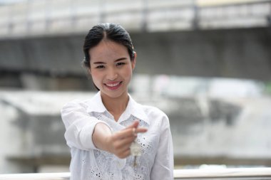 Mutlu genç Asyalı kadın anahtarları tutuyor.