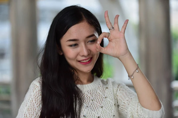 若いアジアの女性はOkサインを示しています — ストック写真
