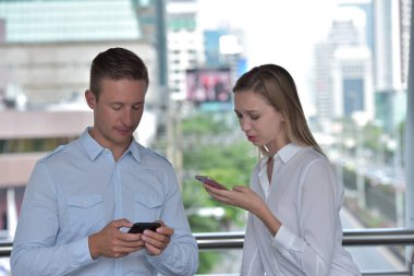 Mutlu turist ile bir telefon ve harita kadın ve iş kullanma Smartphone ve meşgul büyük şehir Street.Lovers konuşma streetbusiness üzerinde bir satırda bir yer ararken bir çiftin önden görünüm gel ve şehir merkezinde bir mobil seyahat hakkında konuşmak.