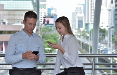 Mutlu turist ile bir telefon ve harita kadın ve iş kullanma Smartphone ve meşgul büyük şehir Street.Lovers konuşma streetbusiness üzerinde bir satırda bir yer ararken bir çiftin önden görünüm gel ve şehir merkezinde bir mobil seyahat hakkında konuşmak.