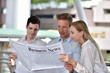 Üç iş adamı gazete okuyor ve şehir merkezinde tartışıyorlar.