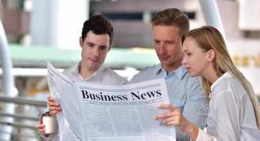 Üç iş adamı gazete okuyor ve şehir merkezinde tartışıyorlar.