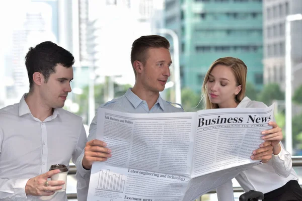 Three Business People Reading Newspaper Discussing City Center — Stock Photo, Image