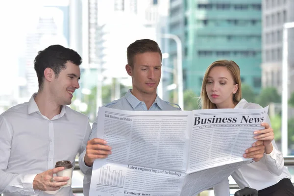 Three Business People Reading Newspaper Discussing City Center — Stock Photo, Image