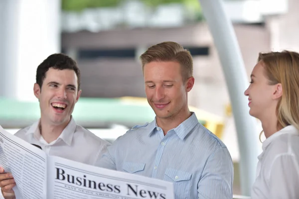 Three Business People Reading Newspaper Discussing City Center — Stock Photo, Image