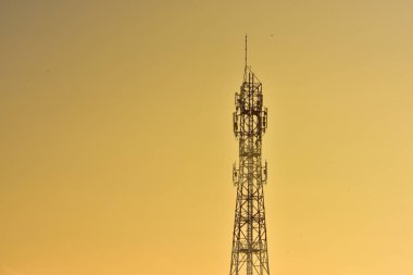 Kablosuz iletişim anteni ile gündoğumu parlak gökyüzü. Turuncu Gökyüzü antenler ile telekomünikasyon Kulesi.