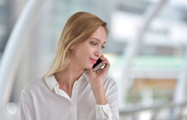 Genç bir kadın cep telefonuyla konuşuyor.