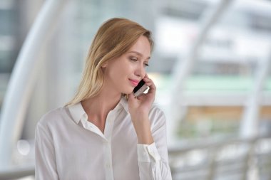 Genç bir kadın cep telefonuyla konuşuyor.