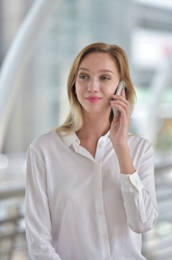 Genç bir kadın cep telefonuyla konuşuyor.