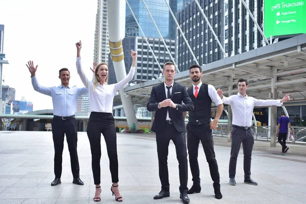 Şehir merkezinde poz veren bir grup iş adamı