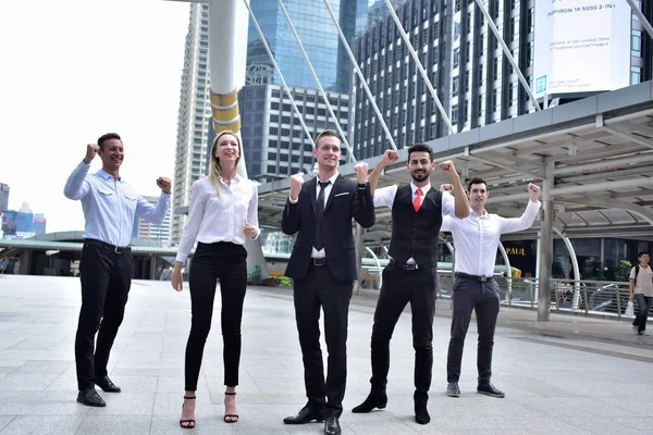 Şehir merkezinde poz veren bir grup iş adamı