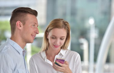 İş adamı ve iş kadını cep telefonu kullanıyor