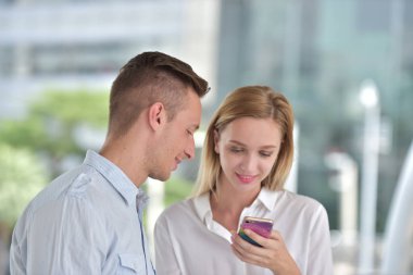 İş adamı ve iş kadını cep telefonu kullanıyor