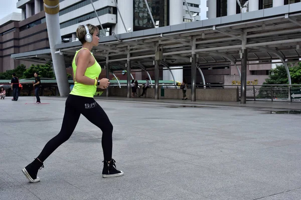 Sports woman is running in city downtown