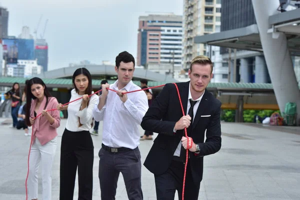 Business team with rope in city downtown