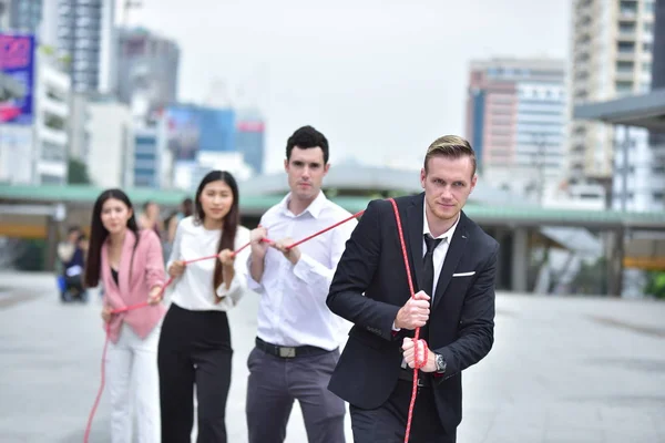 Business team with rope in city downtown