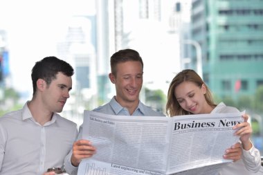 İş adamları şehir merkezinde gazete okuyor.