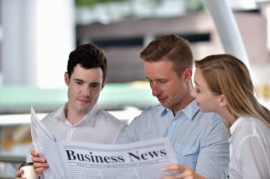 İş adamları şehir merkezinde gazete okuyor. 