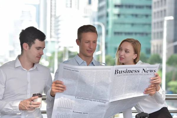 Business people is reading newspaper in city downtown